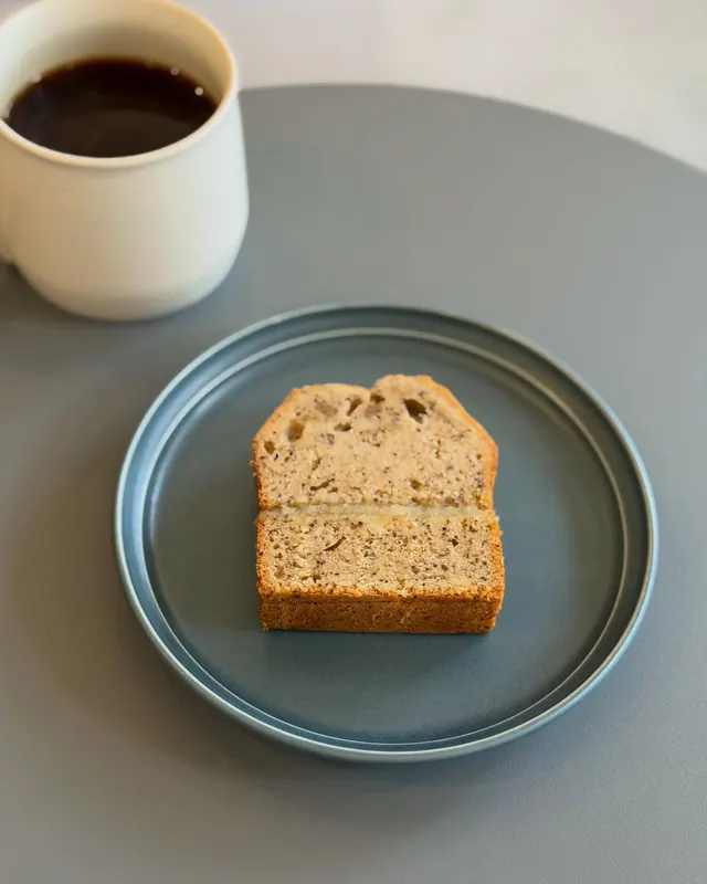 青い皿にのった紅茶とりんごのケーキと、カップのコーヒー